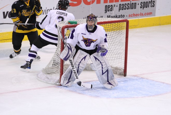 Austin Lee as the goalie in a hockey game against the Michigan Tech Huskies