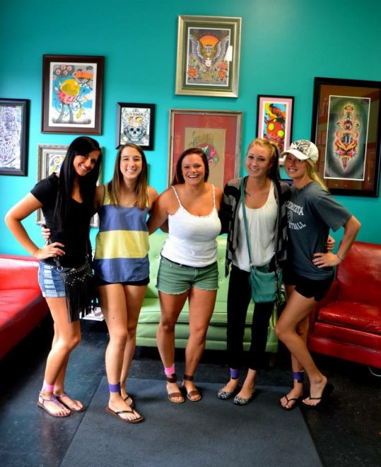Ailee Norton (second from left) with the friends who decided to honor Amy Hoschler with tattoos on their ankles.