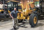 Ryan Thilges stands next to a John Deere paver tractor.